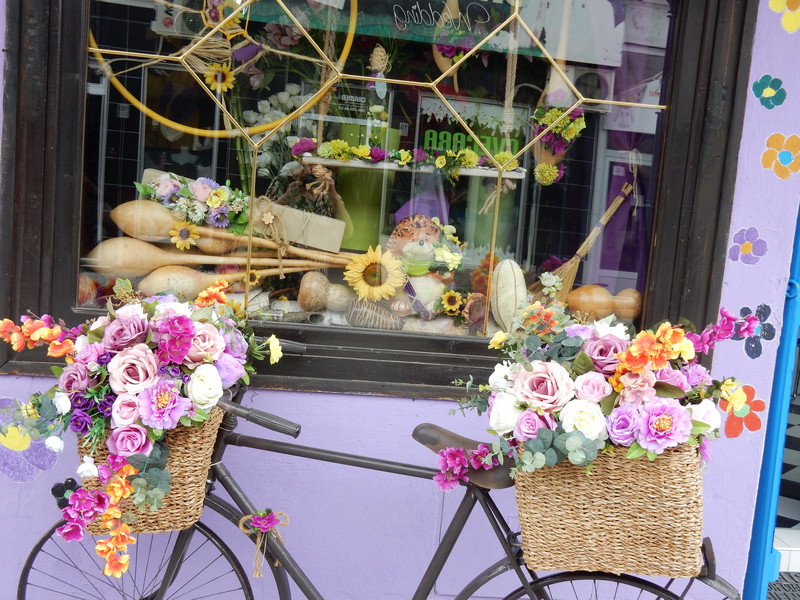 Cveće na starom biciklu kao razglednica za mališane