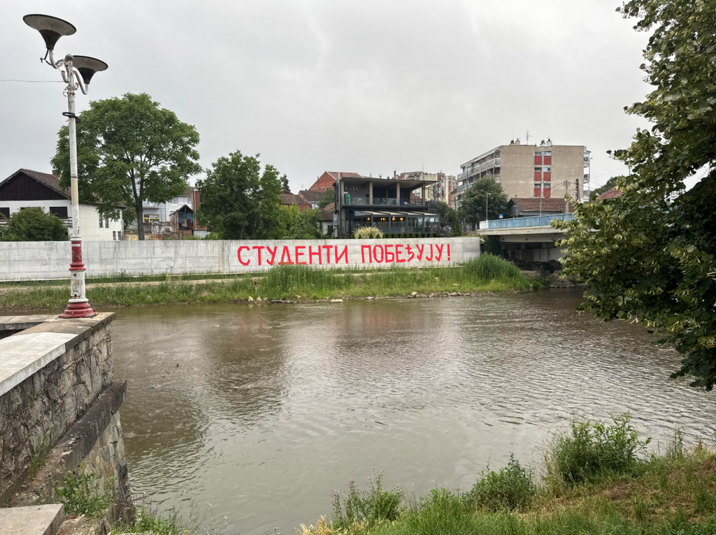 Na zidu pored Vlasine grafit “Studenti pobeđuju” kao dekor za večerašnju tribinu